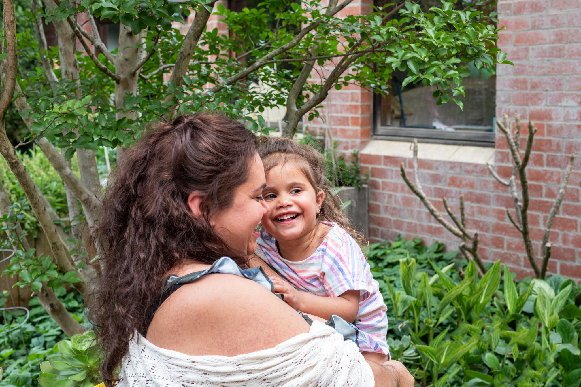 Indigenous women holding daughter and smiling